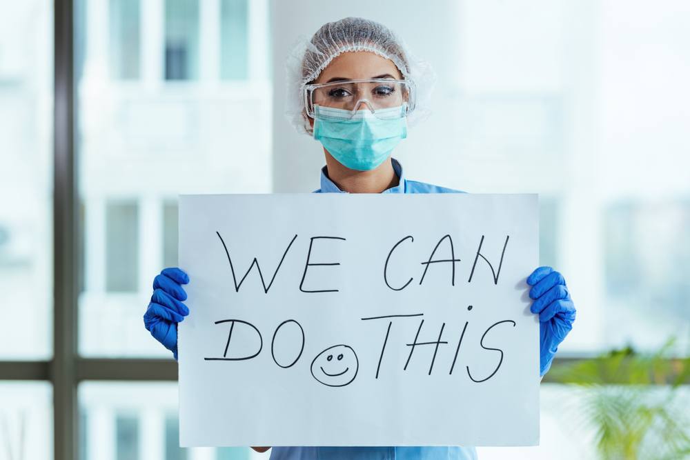 healthcare worker holding a sign