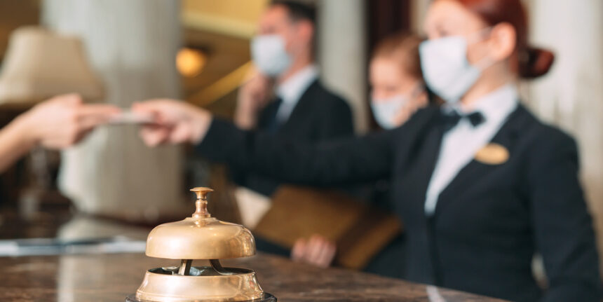 Check,In,Hotel.,Receptionist,At,Counter,In,Hotel,Wearing,Medical